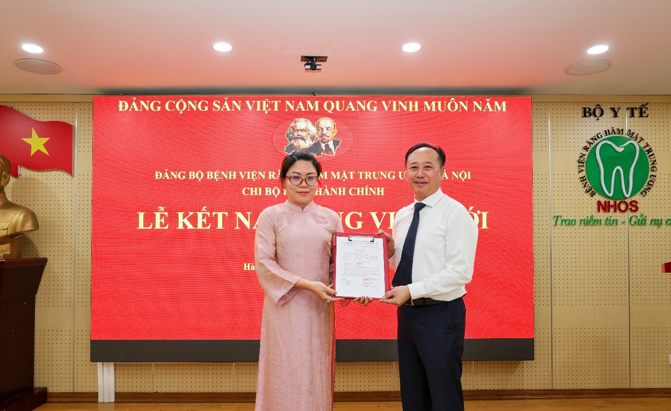 Đồng chí Trần Cao Bính, Bí thư Đảng ủy, Bí thư Chi bộ Khối Hành chính, Giám đốc Bệnh viện trao quyết định kết nạp đảng cho đồng chí Đỗ Trà My